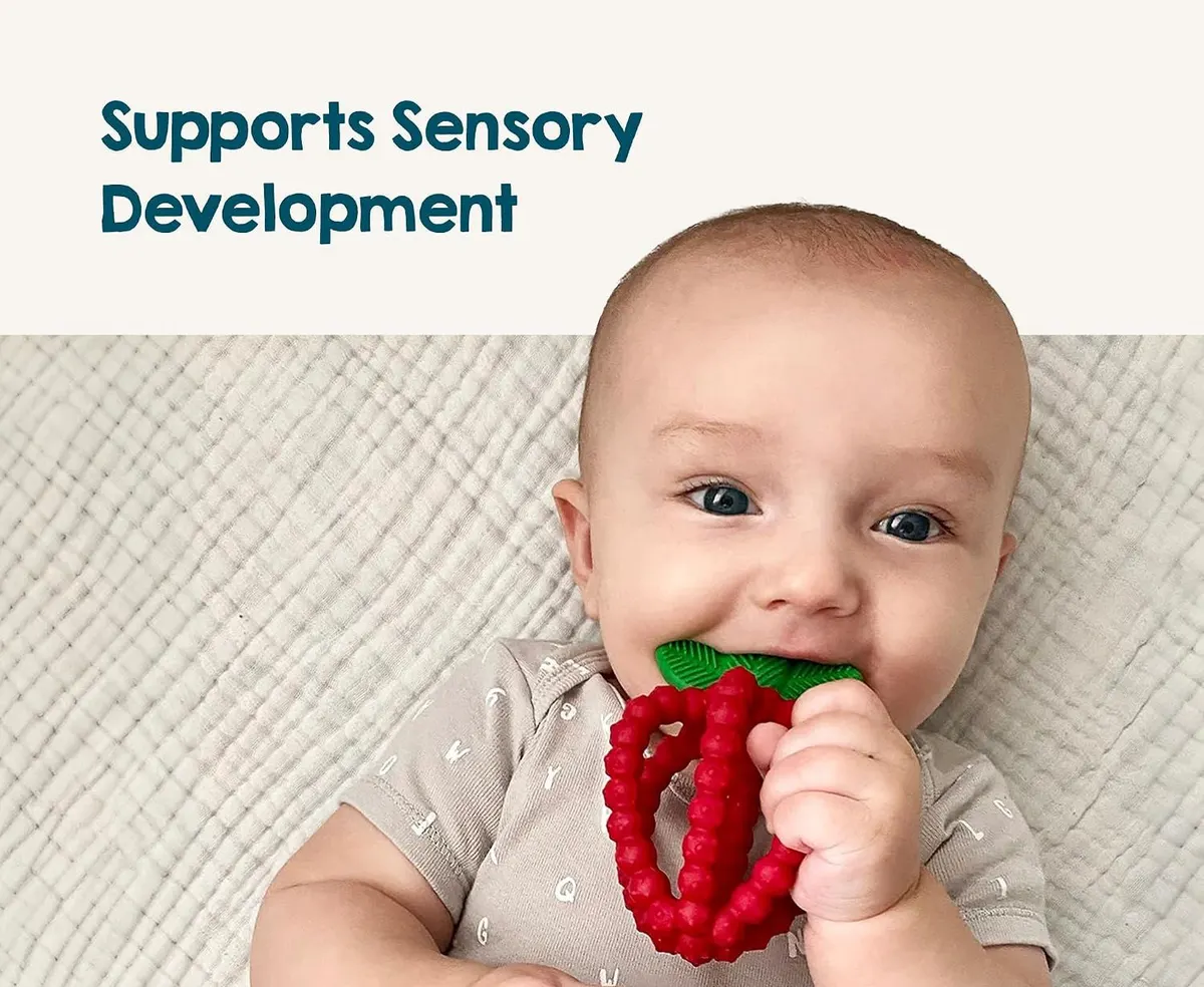 baby chewing a strawberry silicone teething toy