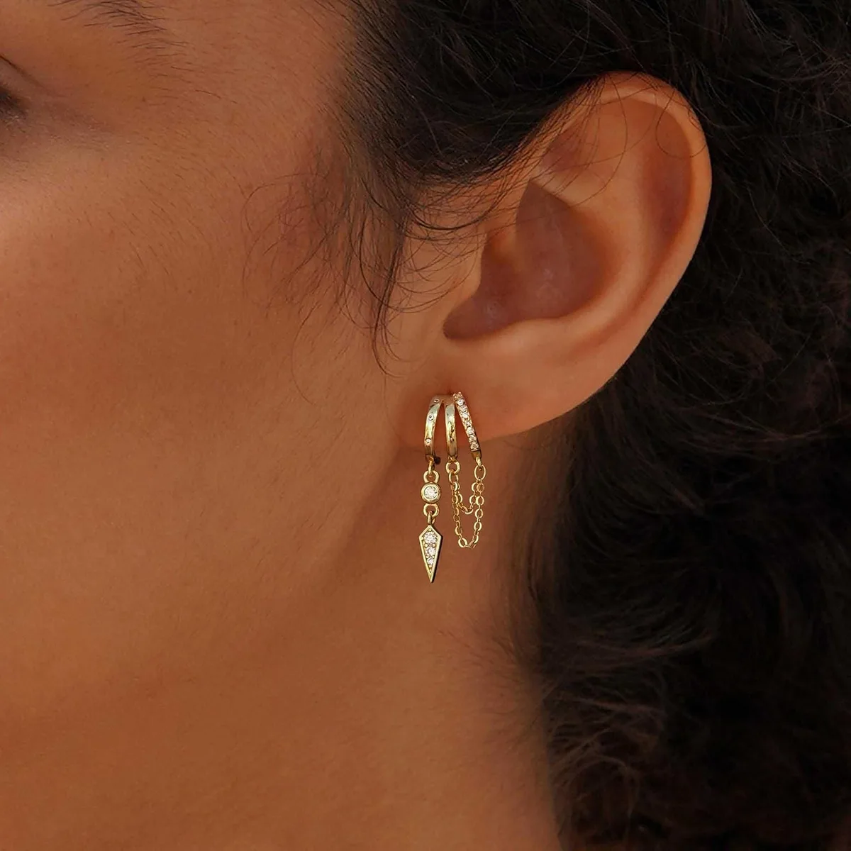 side view of the gold dangle huggie earrings